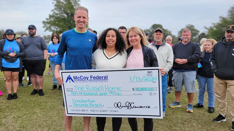 Amanda Brochu presents a $10,000 check to The Russell Home.