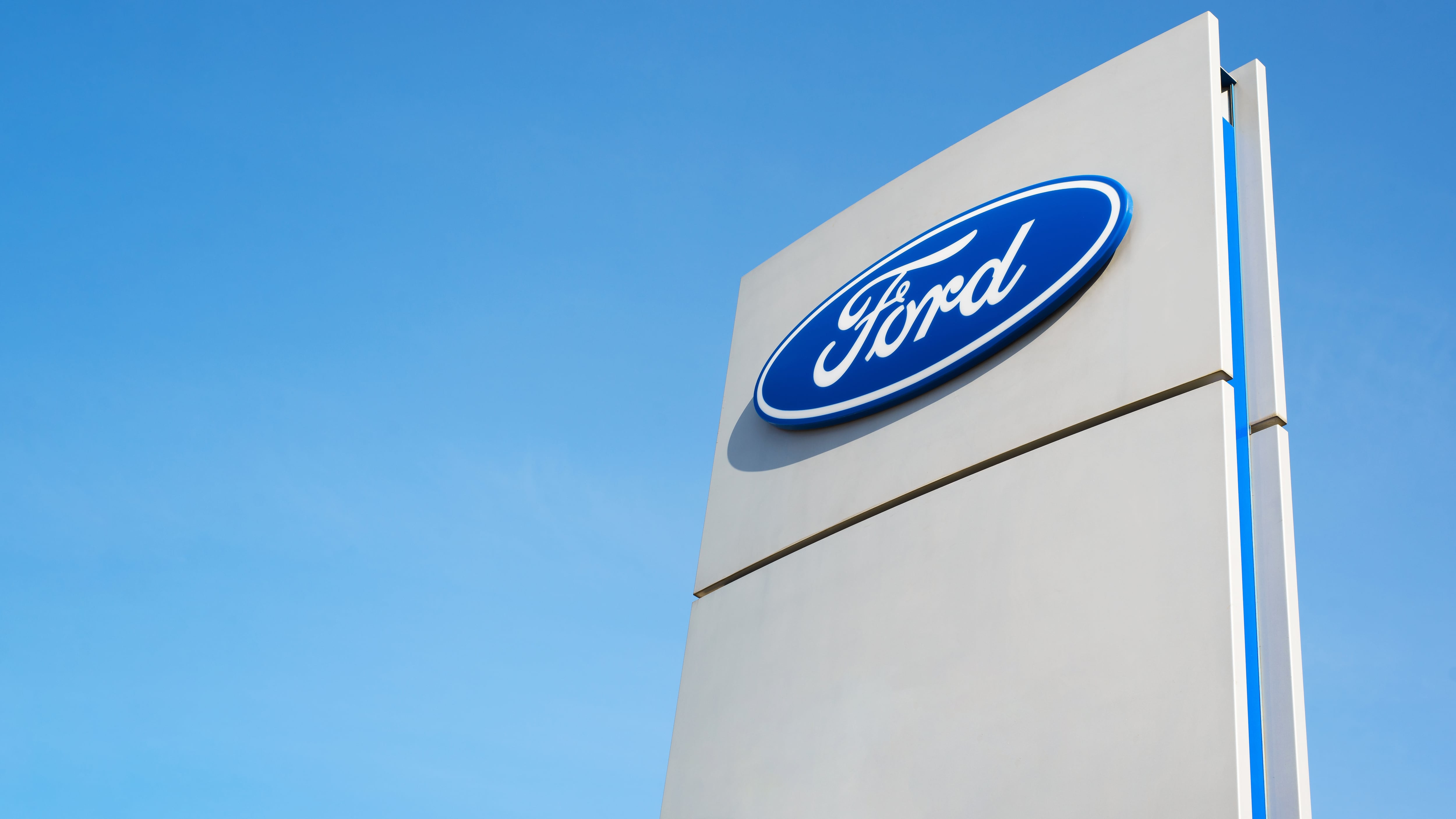 Ford American car company sign, clear blue sky background outside.
